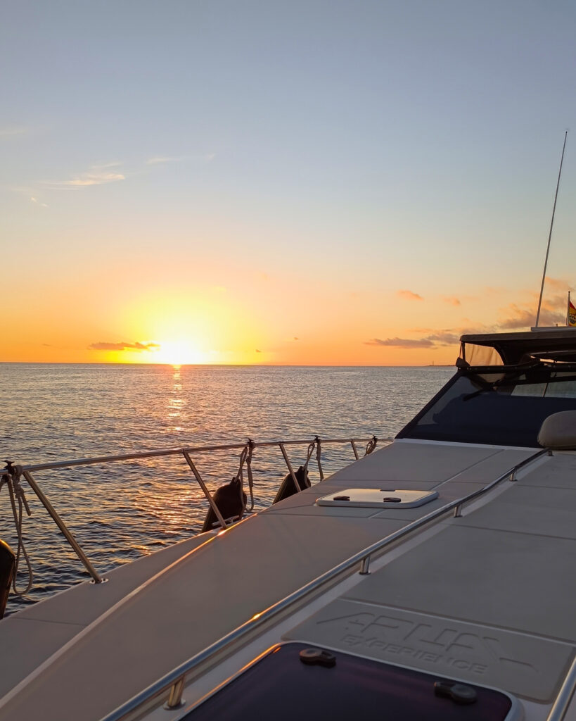 Atardecer sobre el mar visto desde la proa de un yate privado.